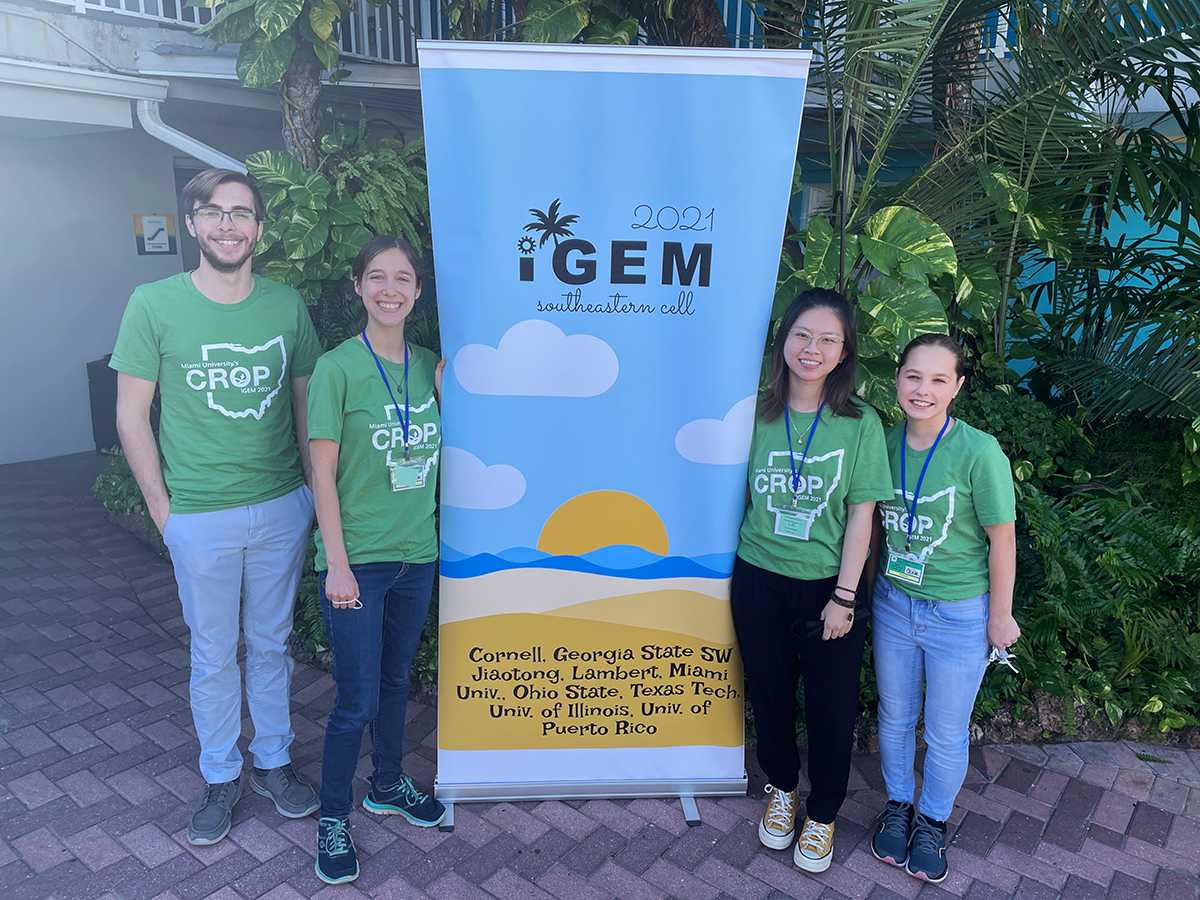 Kyle Lierer, Hope Townsend, Annie Nguyen and Daria Perminova pose in front of iGEM 2021 banner