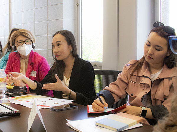 3 IVLP visitors talk and take notes