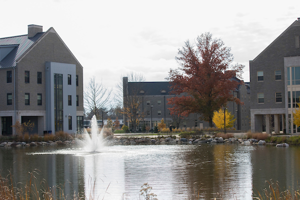 Western campus in the fall, a fountain in a pond fills the foreground
