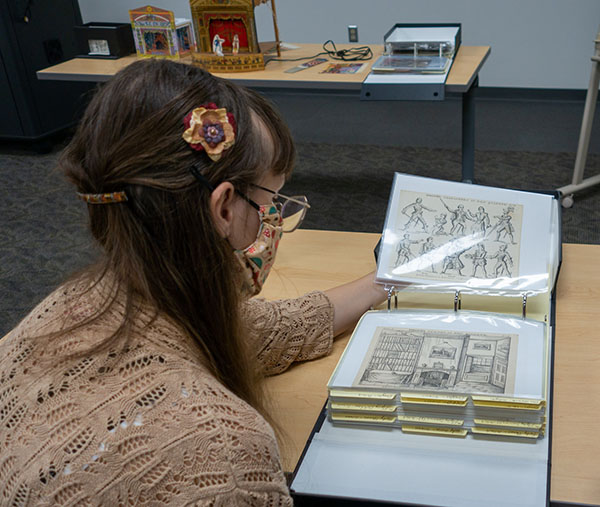 A student looks at illustrations in the Special Collections
