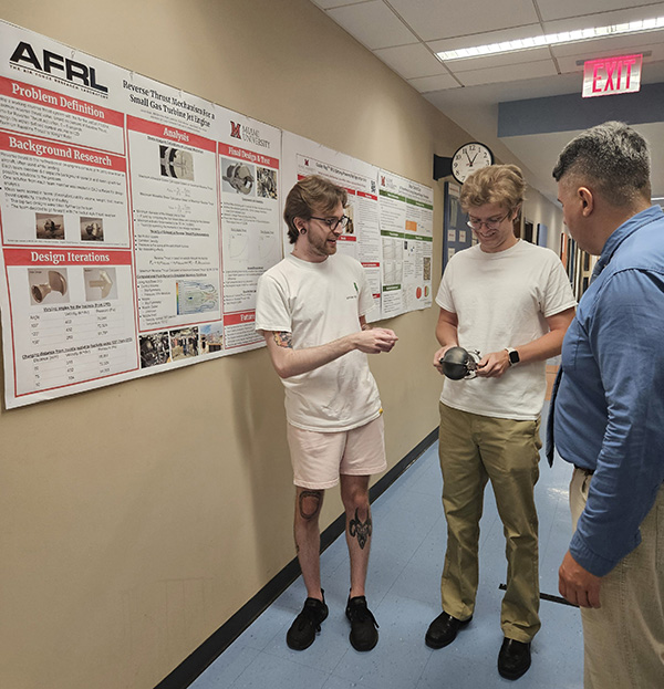 Ukrainian scholar Borys Prydalnyi, right, speaks with Zach Mentzer and Joey Reindel, center, both master's students in Mechanical Engineering (photo courtesy of Stephen Norris).