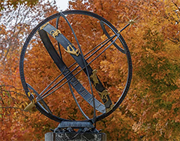 The sundial with colorful fall leaves in the background