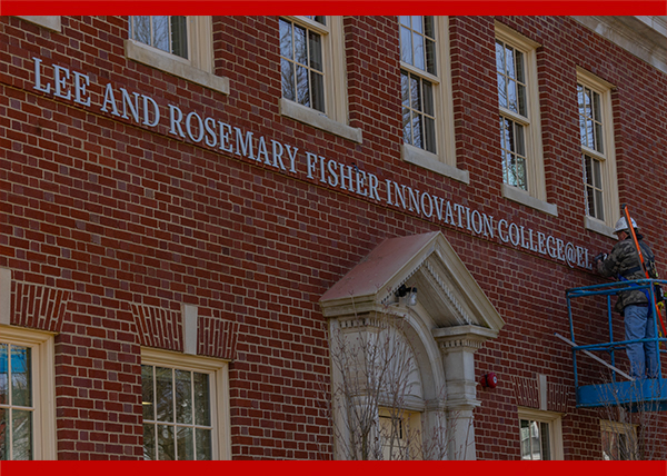 Workers add the Lee and Rosemary Fisher Innovation College@Elm sign