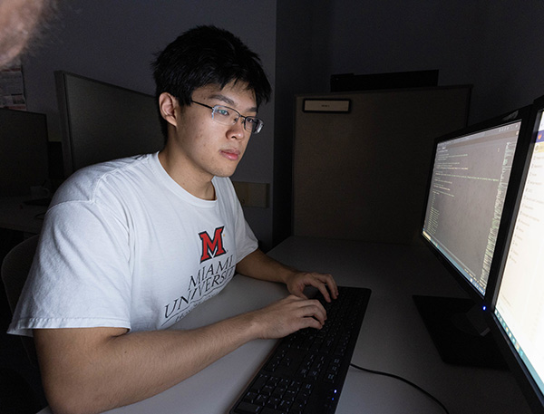 Luke Liang looks into a computer monitor