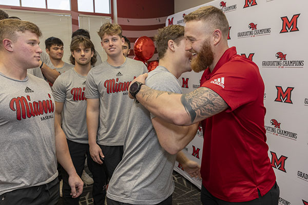 Sam Bachman interacts with members of the Miami baseball team