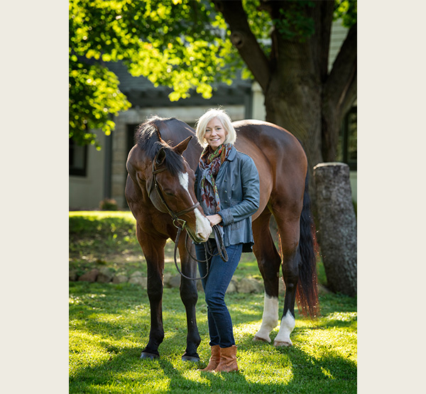 Mary Beth Canfield ’90, a former equestrian team member who now serves on Miami’s Foundation Board, stands beside her horse.