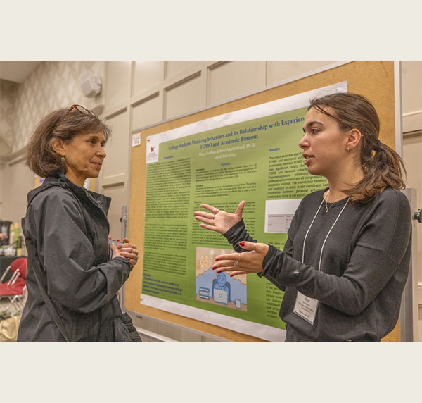 katia del rio tsonis and a student in front of a research poster