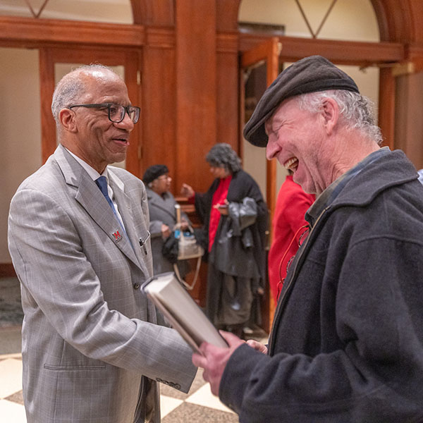 Wil Haygood, left, greeting an attendee at his book launch event