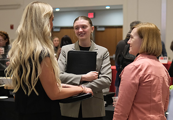 Three students talk at a career day