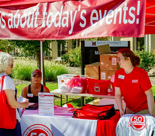 Ruth Orth at a booth handing out T-shirts during the MUH 50th anniversary celebration 