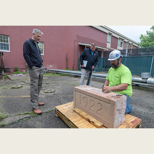 Miami University architect Robert Bell, left, watches as a time capsule is unsealed at Wells Hall.