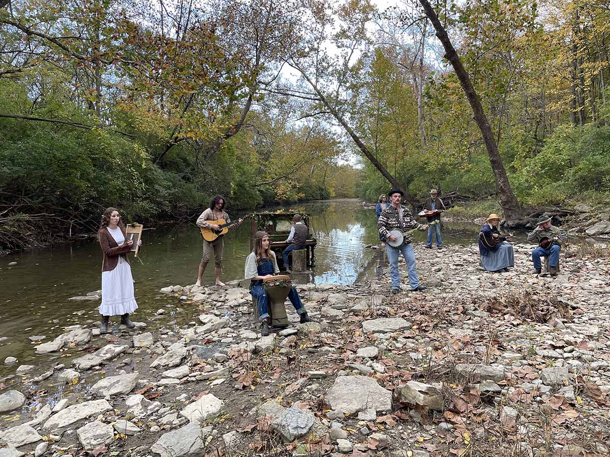 The Bluegrass band featured in the video includes local community members and Miami students . They pose with their instruments in Four Mile Creek
