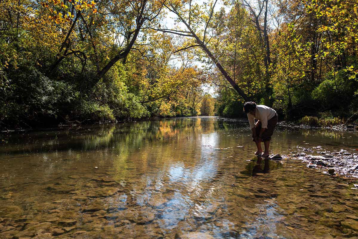A Glee Club member looks into Four Mile Creek 