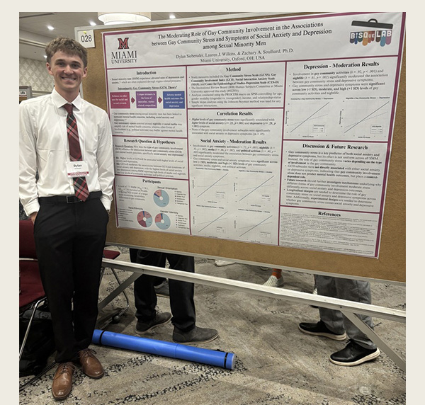 Dylan Siebenaler stands next to his poster at the undergraduate research forum